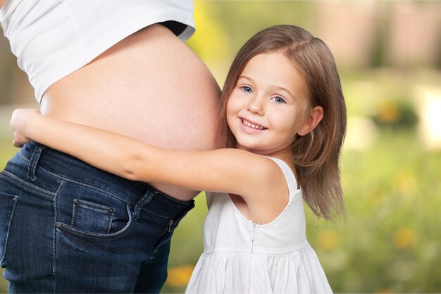 Mooie zwangere vrouw met haar dochter. Geïsoleerd op achtergrond