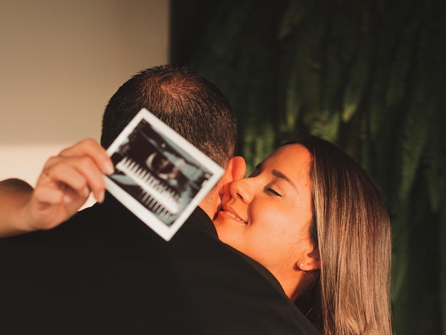 Mooie zwangere vrouw met haar man met een echo in de hand van haar baby