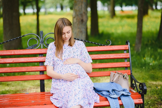 Mooie zwangere vrouw ontspannen in het park