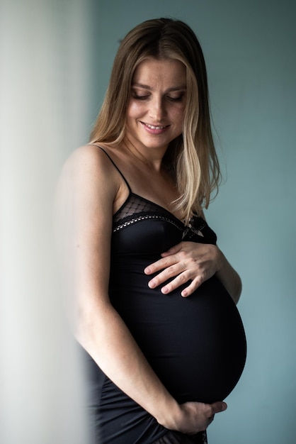 Mooie zwangere vrouw op donkere achtergrond