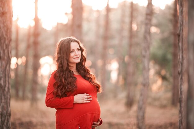 Mooie zwangere vrouw van 25-30 jaar die buiten in zonlicht rust