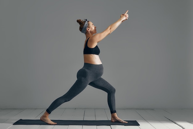 Mooie zwangere vrouw workout Fitness doen tijdens de laatste maanden van de zwangerschap Yogaposities