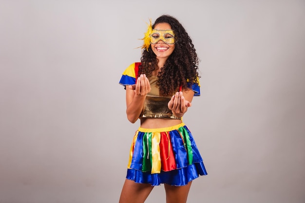 Mooie zwarte Braziliaanse vrouw met frevo kleding carnaval Een masker dragen dat uitnodigt om met je handen te bellen