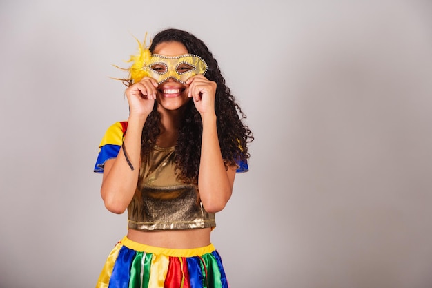 Mooie zwarte Braziliaanse vrouw met frevo outfit en paraplu carnaval carnaval masker op gezicht zetten