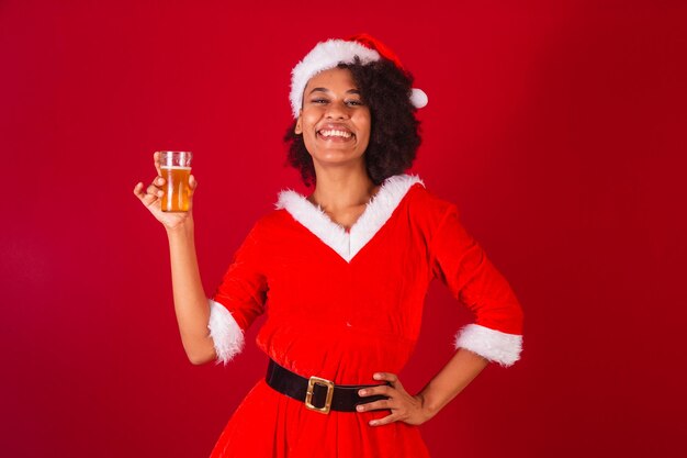 Mooie zwarte braziliaanse vrouw verkleed als kerstman mama claus met glas bier