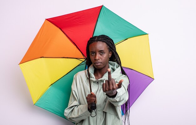 Mooie zwarte vrouw die zich boos, geïrriteerd, opstandig en agressief voelt. paraplu concept