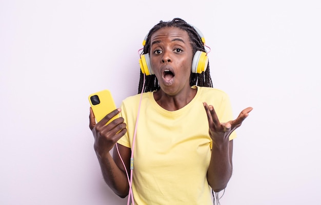 Mooie zwarte vrouw voelt zich extreem geschokt en verrast. luisteren muziek concept
