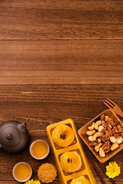 Moon cake for MidAutumn Festival delicious beautiful fresh mooncake on a plate over dark wooden background table top view flat lay layout design concept