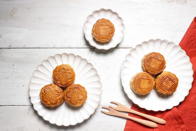 Moon cake mooncake table setting - pasticceria tradizionale cinese di forma rotonda con tazze da tè su un tavolo.