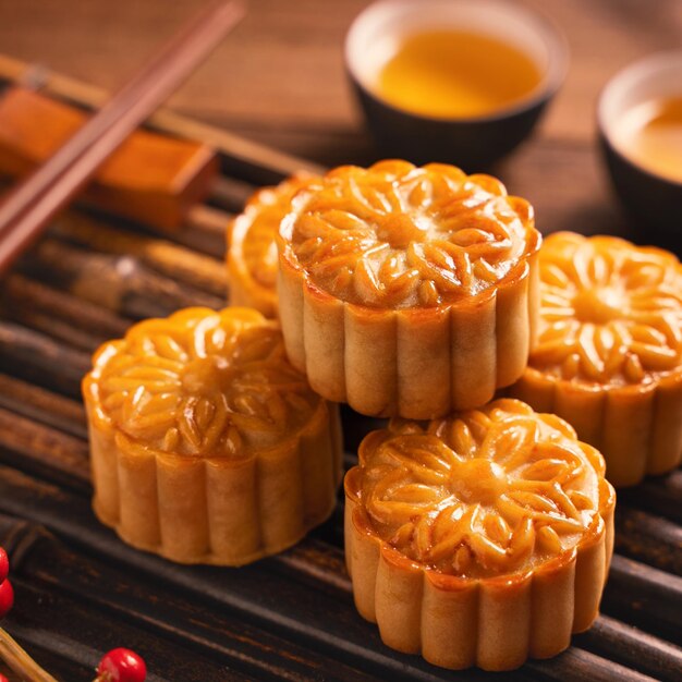 Moon cake mooncake table setting round shaped chinese traditional pastry with tea cups on wooden background midautumn festival concept close up