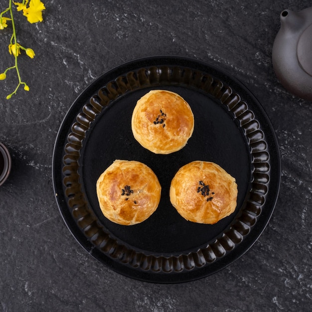 Moon cake yolk pastry mooncake for midautumn festival holiday\
top view design concept on dark wooden table with copy space flat\
lay overhead shot