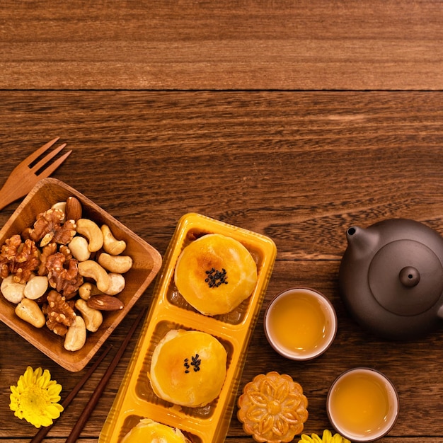 Moon cakes with tea on dark wooden table holiday concept of MidAutumn festival traditional food layout design top view flat lay copy space