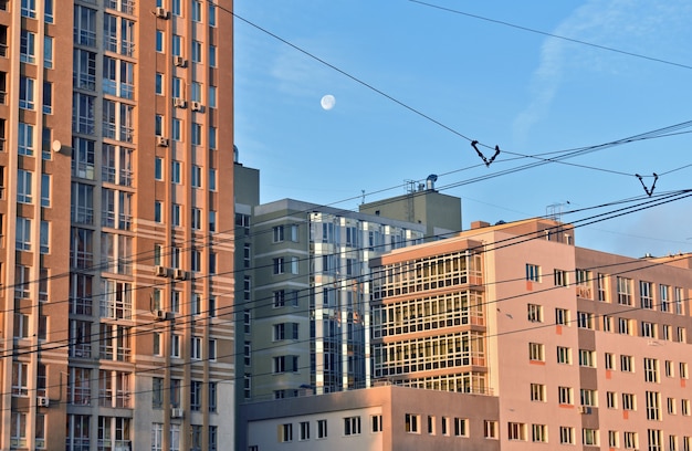 The moon glows over the houses of new buildings