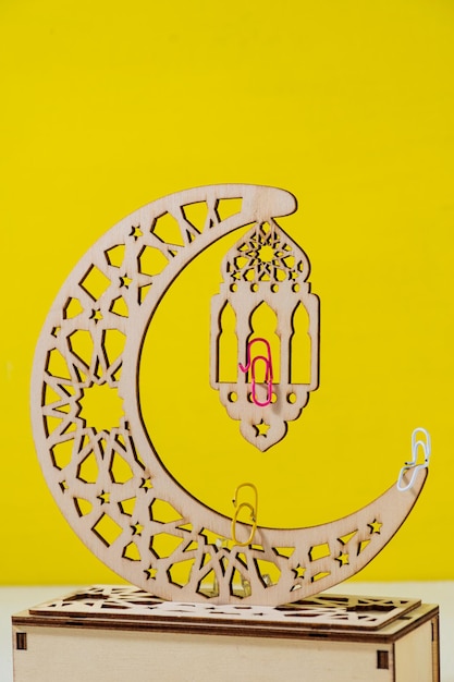 moon lamp with Islamic ornament and red paper clip on it Yellow Background