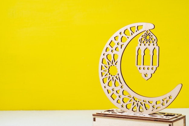あなたのテキストのための黄色の背景の空白にイスラムの装飾品と月のランプ