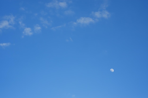 The moon shining in the daytime in the middle of the sky surfing brightly colored In Thailand