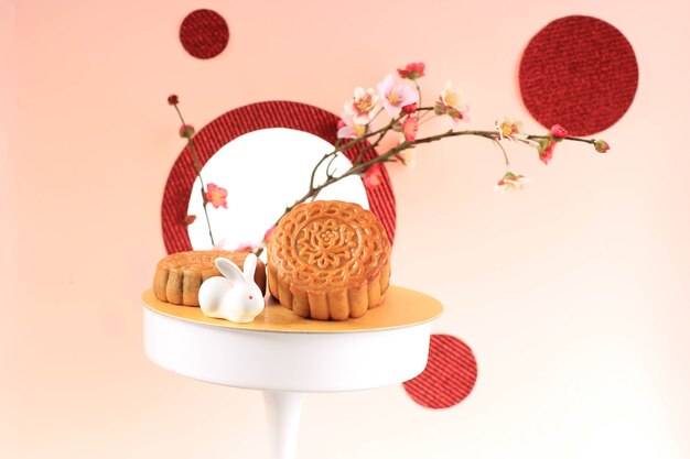 Mooncake на светло-розовом фоне с розовым цветком. Концепция лунного пирога на фестивале середины осени. Лунный пирог Популярный как Kue Bulan.