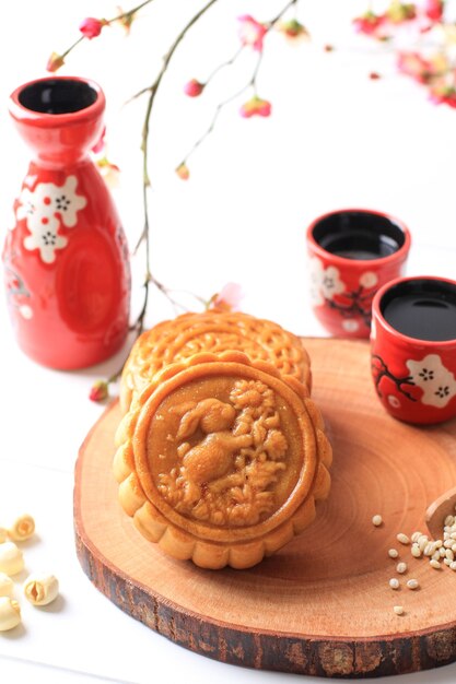 Mooncake on White Background with Pink Flower. Concept Moon Cake on Mid Autumn Festival. Mooncake Popular as Kue Bulan