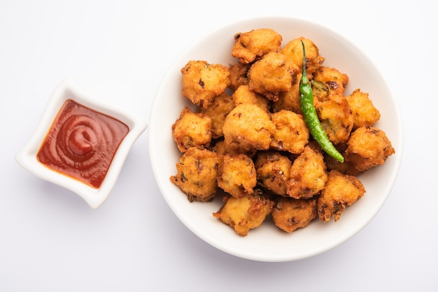 Moong Dal Vada или mungode Pakoda, Dalwada, Pakora или Mungdal Bhajiya или Yellow Split Gram Fritters Подаются с томатным кетчупом