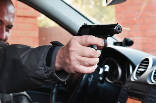 Moordenaar in een auto met een pistool