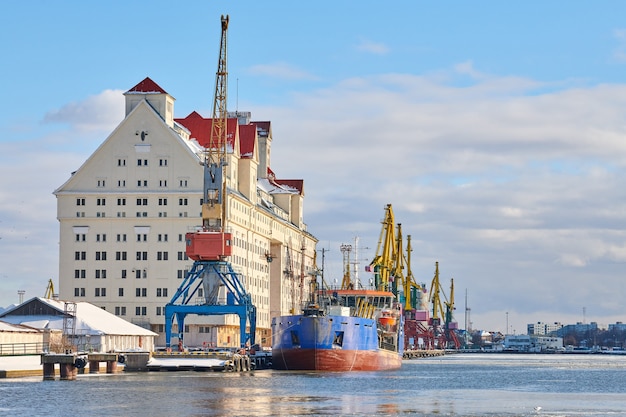 Moored cargo ships and harbor cranes in port