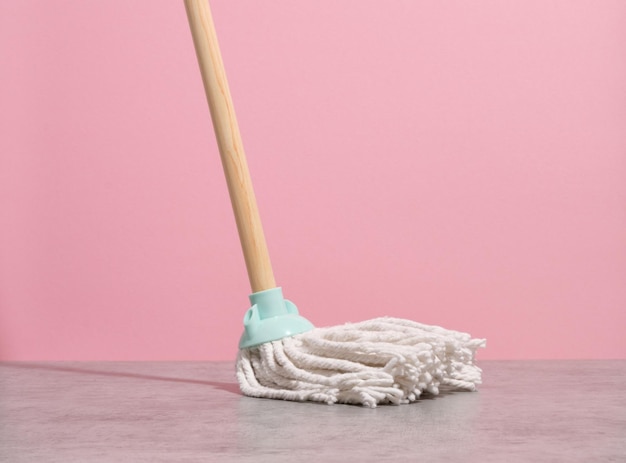 Photo mop with a white rag in the process of washing a dirty surface household equipment