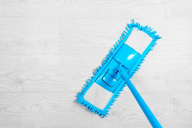 Foto mop in microfibra bagnata blu con detergente kit di disinfezione per la pulizia su un pavimento bianco isolato concetto di pulizia