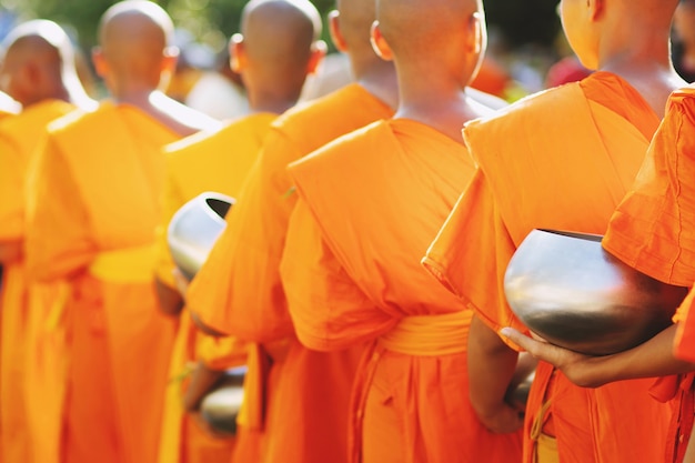 Photo more monks with hand holding give alms bowl which came out of the offerings in the morning at buddhist temple