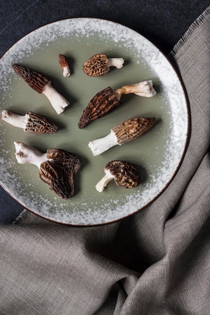 Morel mushrooms on a plate on black background