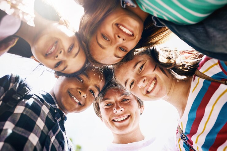 Foto morgen is van ons laag hoekportret van een groep diverse schoolkinderen die in een groepje staan
