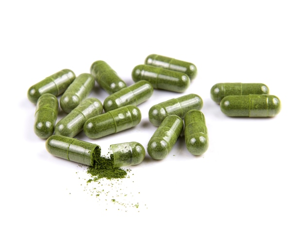 Moringa capsule pills on white surface