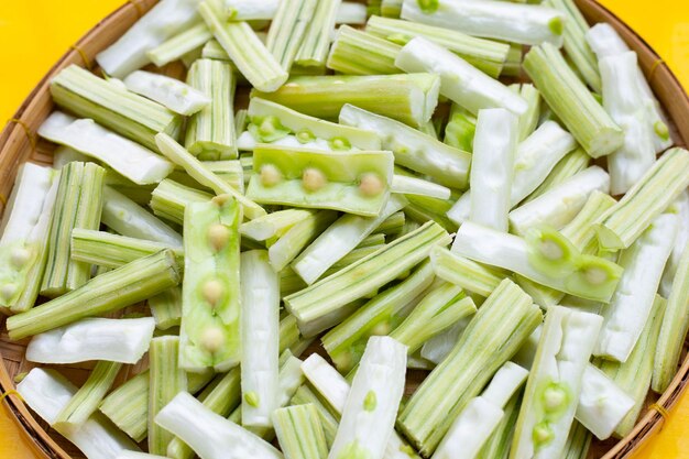 Moringa oleifera in stukjes gesneden in bamboe geweven plaat op gele achtergrond