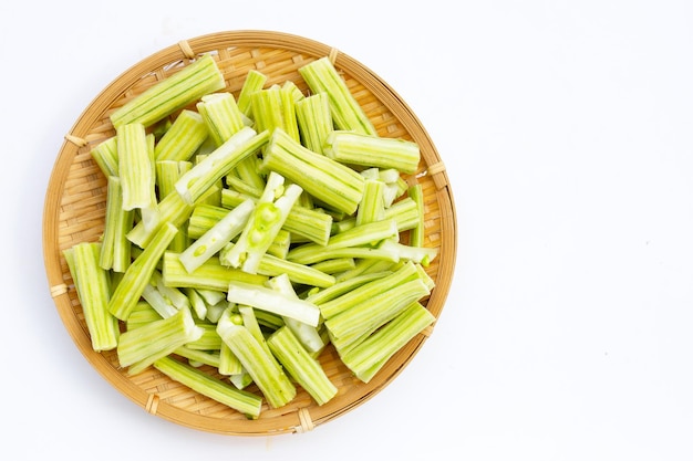 Moringa oleifera in stukken gesneden in bamboe geweven plaat op witte achtergrond