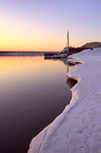 Morning on the bank of the Ob The snowy edge of ice on the river in spring the port pier