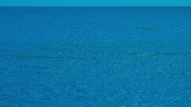 朝の青い静かな海 自然の青い背景 広い開いた海面 波の波紋