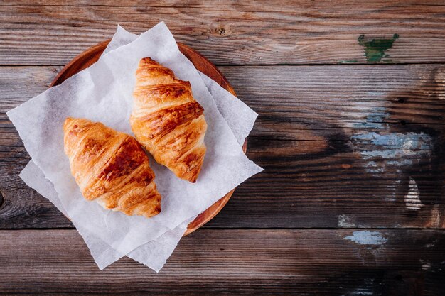 Colazione mattutina cornetti al forno fatti in casa su fondo rustico in legno vista dall'alto