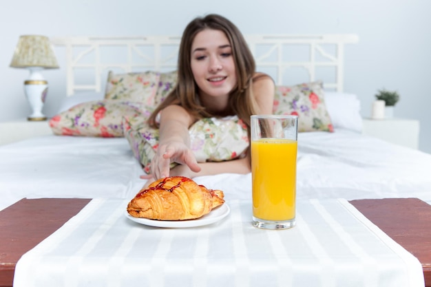 집에서 침대에서 젊은 아름다운 소녀의 아침과 아침 식사