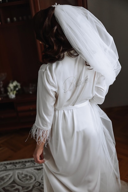 신부 의 아침 에  ⁇  은 실크 로브 를 입은 여자 가 결혼식 꽃다발 을 들고 있다