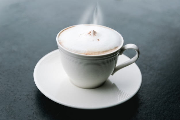 Morning cappuccino coffee on a black table