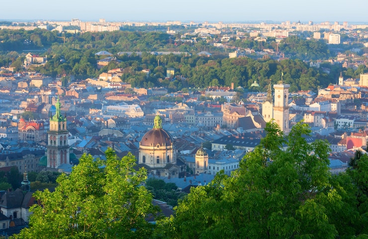 Фотография утренняя панорама центральной части города львова (украина) с холма "высокий замок" (в боковых лучах солнца).