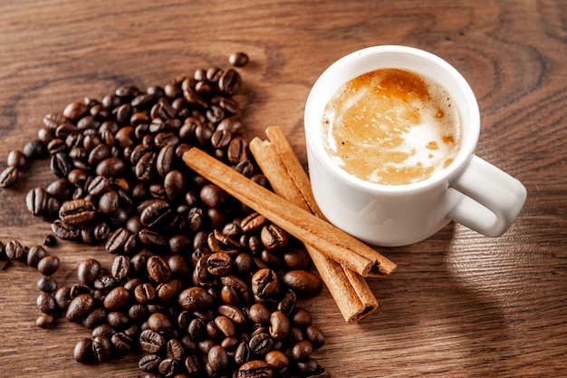 Morning coffee Coffee cup cinnamon and coffee beans on wooden background Top view