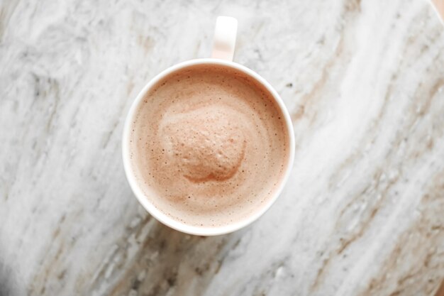 Morning coffee cup with milk on marble stone flat lay hot drink\
on table flatlay top view food photography and recipe inspiration\
for cooking blog or cookbook