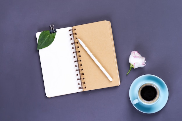 朝のコーヒーマグカップ、空のノートブック、鉛筆とテーブルに白いトルコギキョウの花、居心地の良い朝食、トップビュー