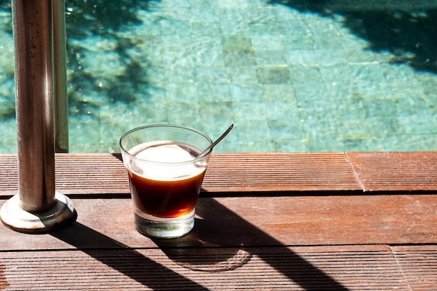 プールのそばで朝のコーヒー プールの近くでコーヒーグラス
