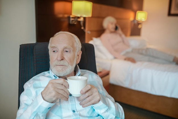 Photo morning coffee. senior bearded man having his morning coffee and looking thoughtful