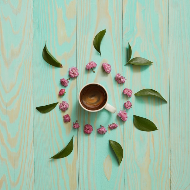 Morning Cup of coffee and a beautiful flowers and leaves, top view. Cozy Breakfast. Flat lay style.