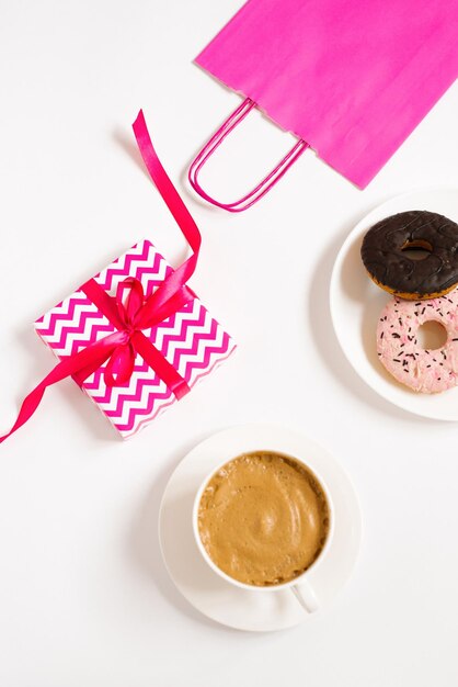 Morning cup of coffee sweet donuts a gift box with a paper bag on a white table on top of a wonderful breakfast Flat lady style