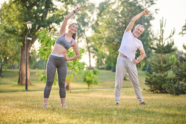 Morning exercising. A mature couple exercising in the park