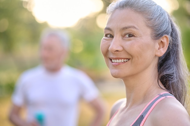 Morning exercising. A picture of a pretty mature woman and a man stading next to her