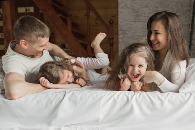 Foto famiglia mattutina i bambini con i genitori che giocano a letto svegliandosi da un sogno mi sono appena svegliato amore